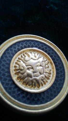 Pre owned metal mythology face gold tone with enamel clothes button.