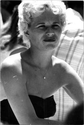 Pretty woman sitting in the sun wearing black swim suit Found Photo V052