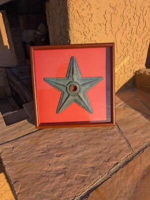 Vintage star shaped anchor plate greenish blue mounted on red matte background 