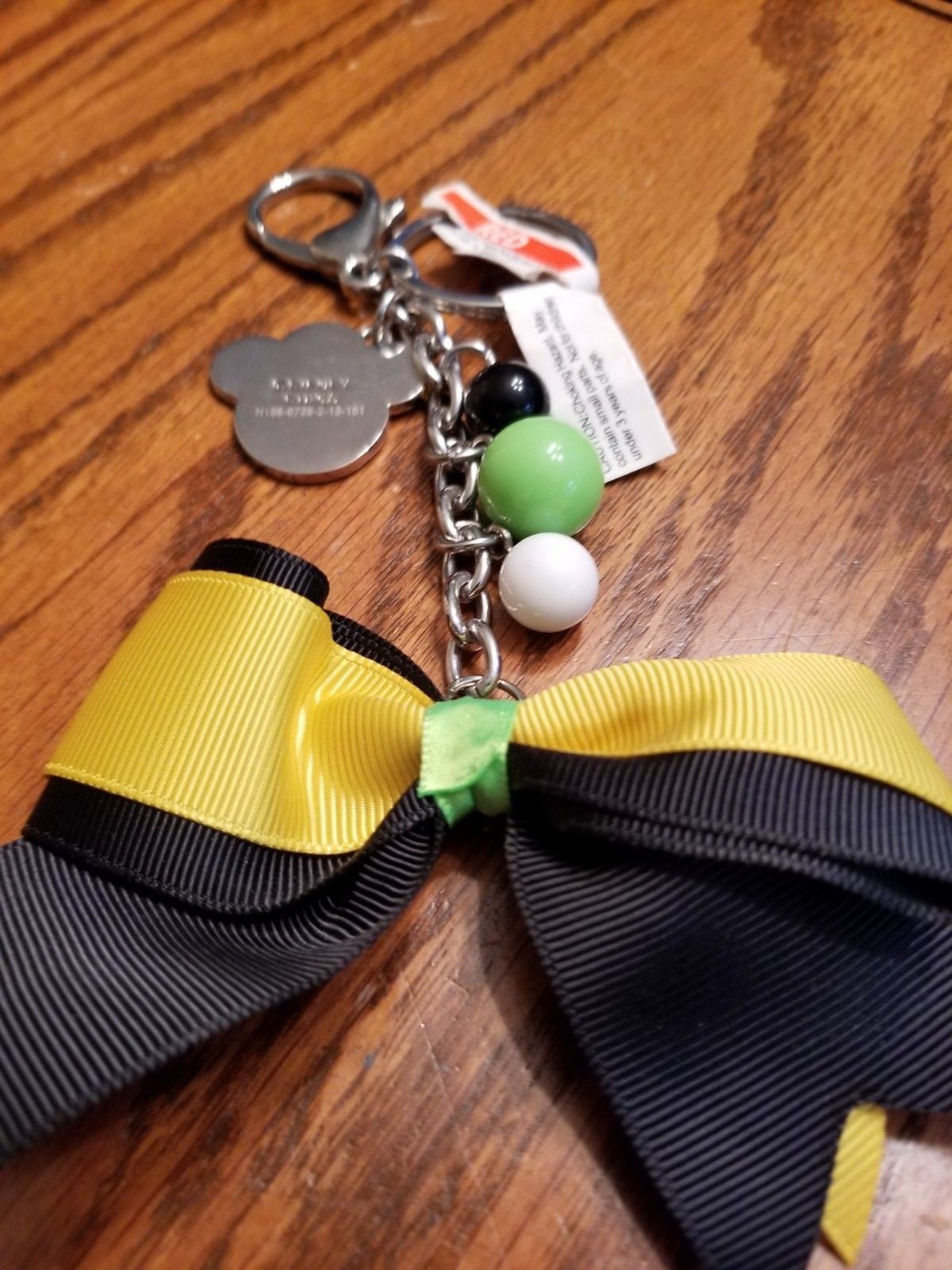 DISNEY PARKS, BOW PAW BLACK YELLOW  KEYCHAIN