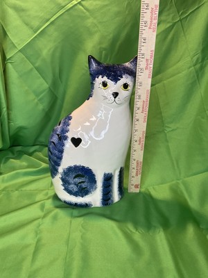 White ceramic cat with blueprints heart cut out