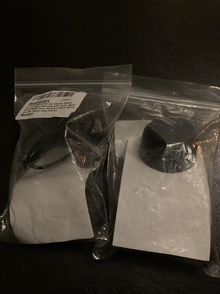 Two sealed plastic bags with black products on table.
