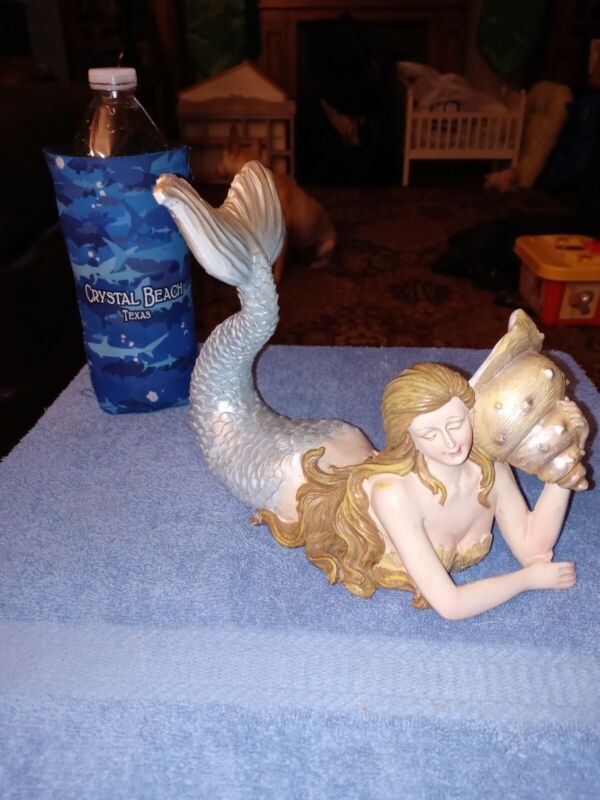 Very Old Beautiful Mermaid holding a seashell to her ear 