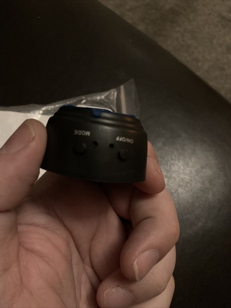 Hand holding a small camera lens.