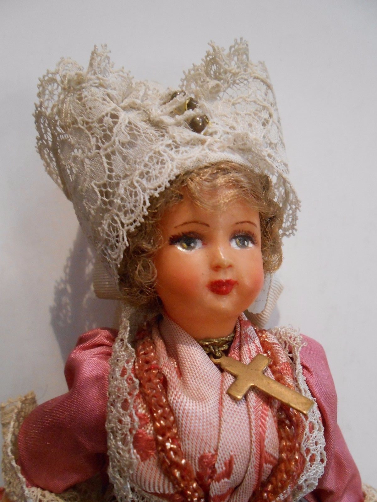 1950's era souvenir doll from Unknown Country. Wearing a cross around her neck.