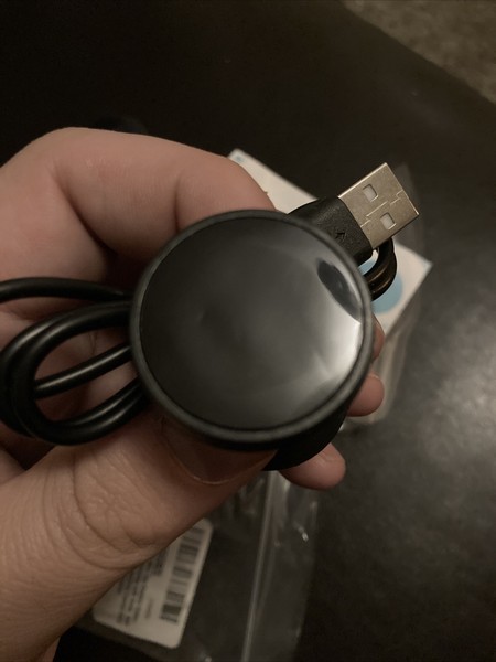 Hand holding a USB charging cable.