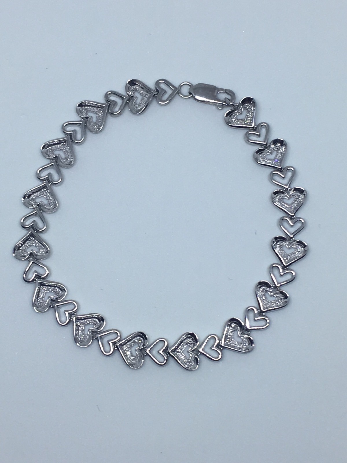 Zales 1/10 CT. T.W. Diamond Tilted Heart Link Bracelet in Sterling Silver