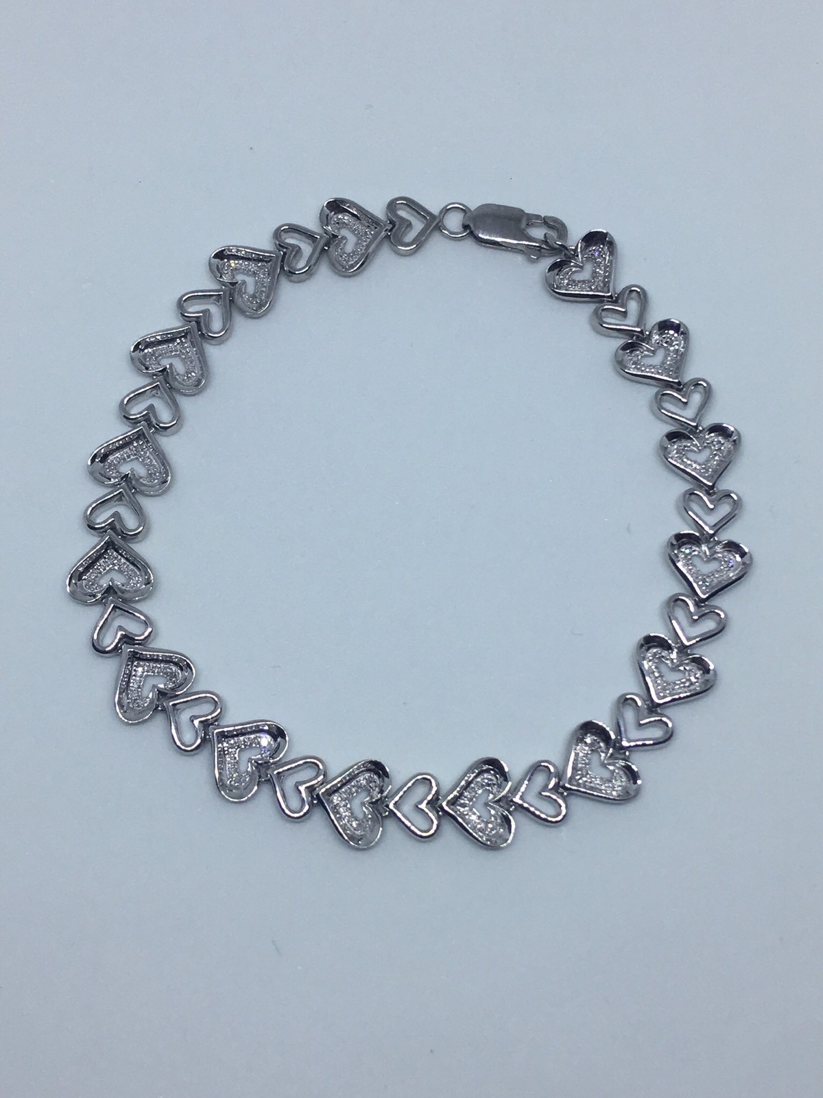 Zales 1/10 CT. T.W. Diamond Tilted Heart Link Bracelet in Sterling Silver