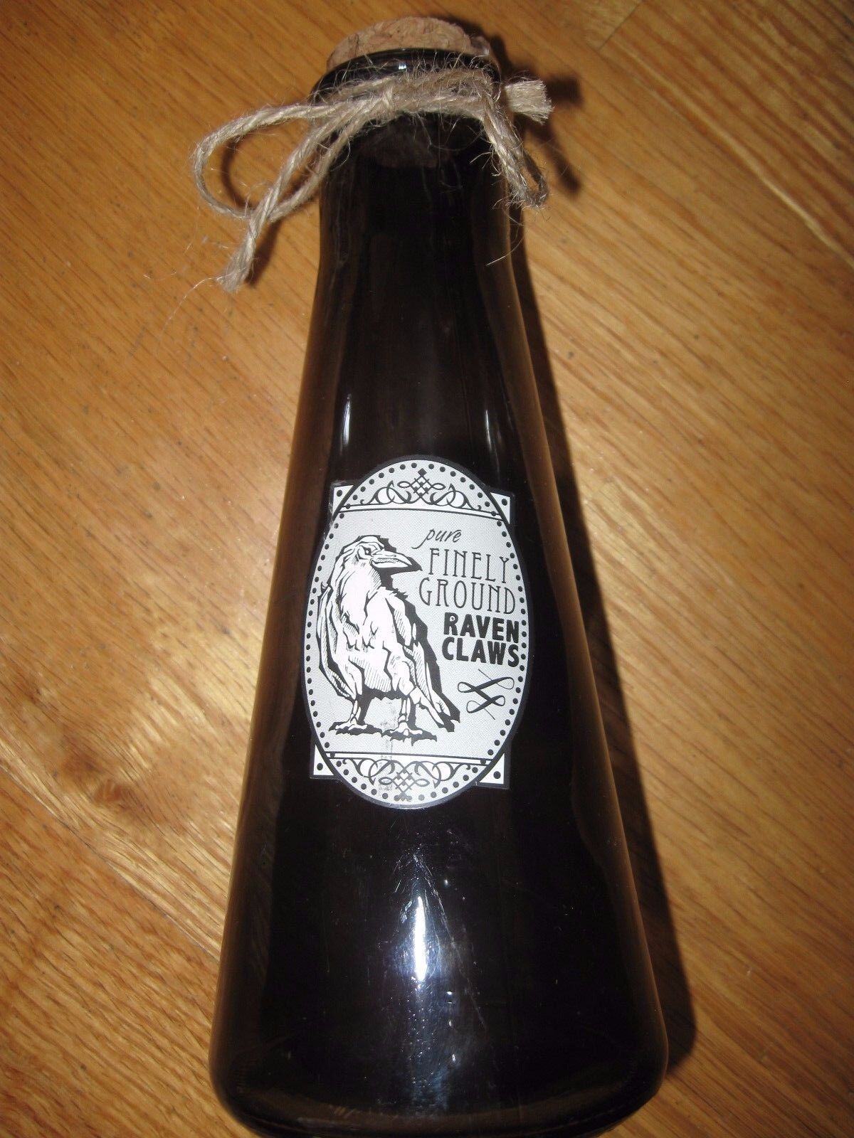 Finely Ground Raven Claws Label on a Corked and Sealed SmokeColored Empty Bottle