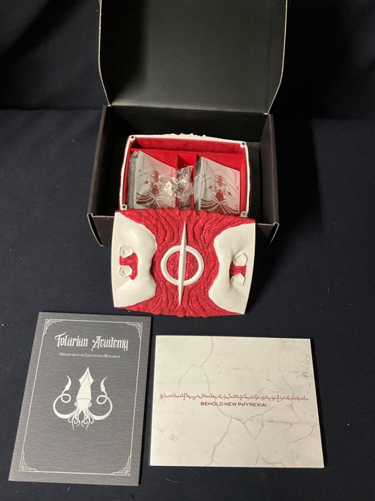 Beadle + Grimm Behold New Phyrexia Delibox, Dice, Sleeves Beadle + Grimm Behold New Phyrexia Delibox, Dice, Sleeves