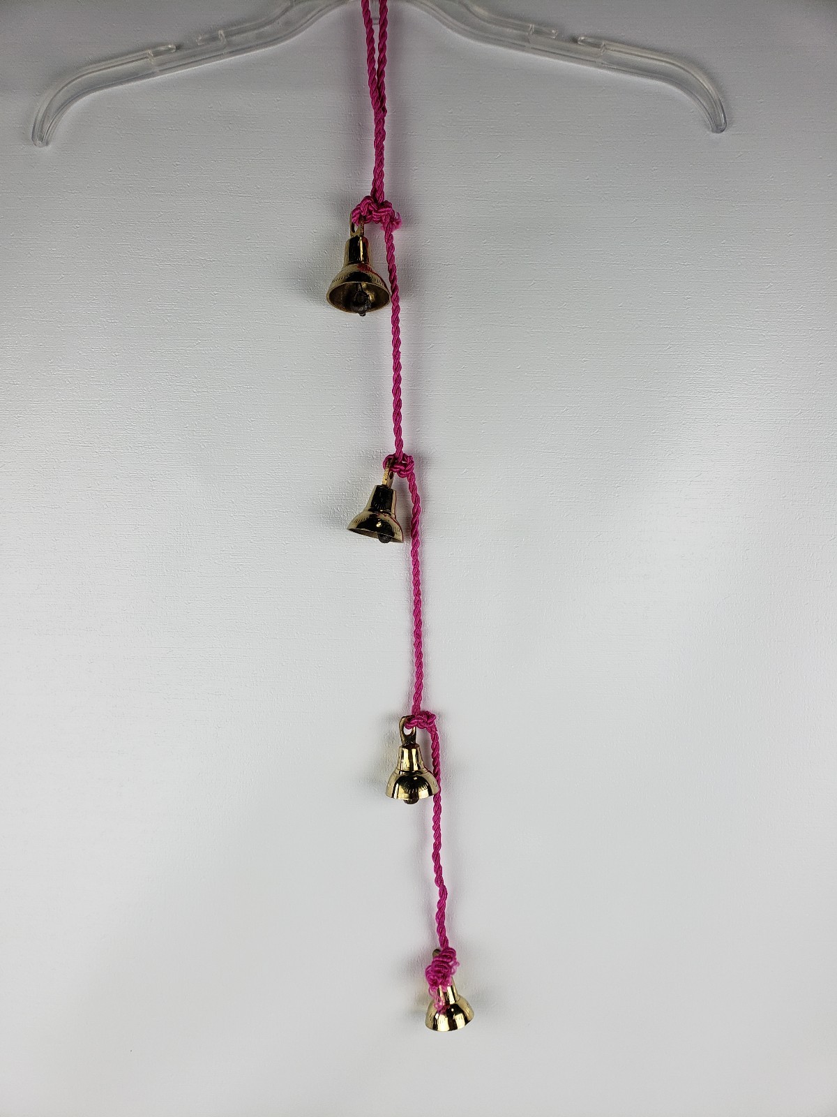 4 Brassy Bells Strung on a Pink Rope India Same Shape Different Sizes
