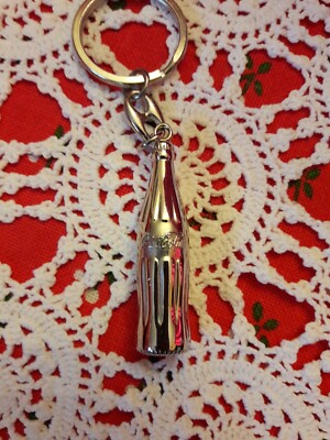 porte clefs bouteille Coca Cola en métal argenté, objet publicitaire neuf.
