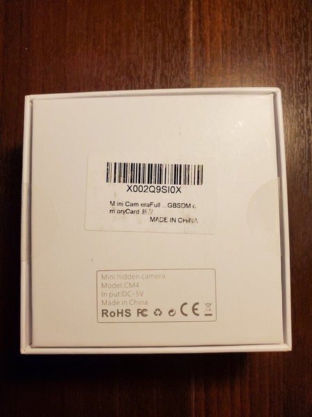 Mini hidden camera product packaging with barcode and labels.