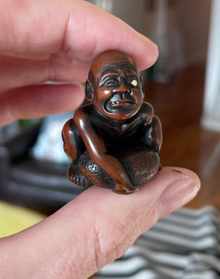 Antique Japanese netsuke of a blind man lifting a stone. 19th Century. MEIJI.