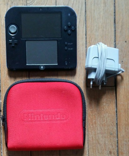 Image Console Nintendo 2DS noire et bleue avec chargeur, housse et jeu Mario Kart 7 Image Console Nintendo 2DS noire et bleue avec chargeur, housse et jeu Mario Kart 7