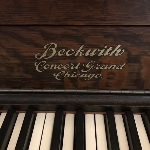 Oak Empire Revival style upright piano by the Beckwith Piano Company