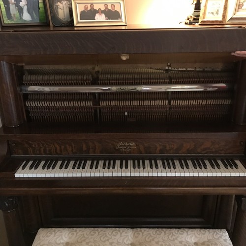 Oak Empire Revival style upright piano by the Beckwith Piano Company