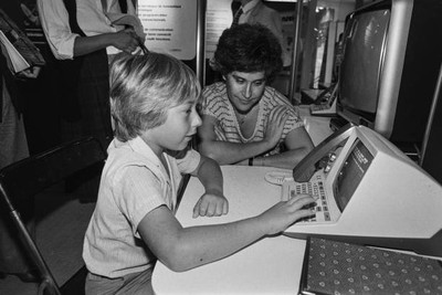 Child discovering a Minitel prototype at the 'Vidcom' in Cannes, i- Old Photo