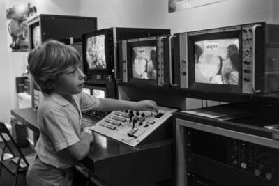 Child using a television production console at the 'Vidcom' in Can- Old Photo