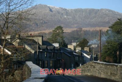 PHOTO  A LONELY FIGURE CROSSES THE BRIDGE IN DOLWYDDELAN MOEL SIABOD LOOMS OVER