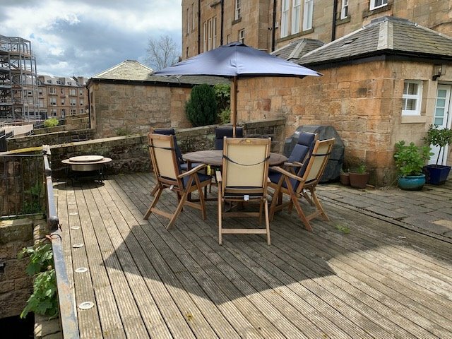 large wooden patio table, 6 chairs and parasol in West 