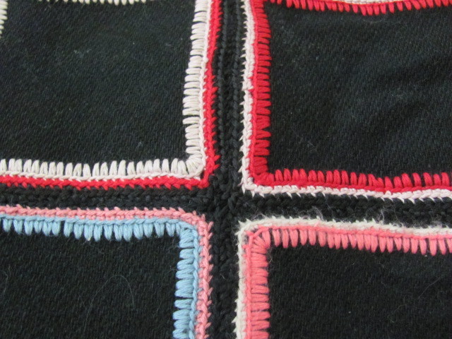 Vintage black wool quilt with colorful stitching crocheted edges