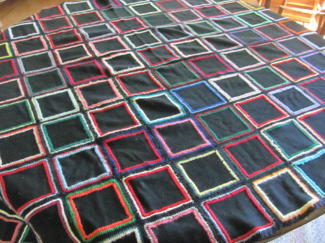 Vintage black wool quilt with colorful stitching crocheted edges