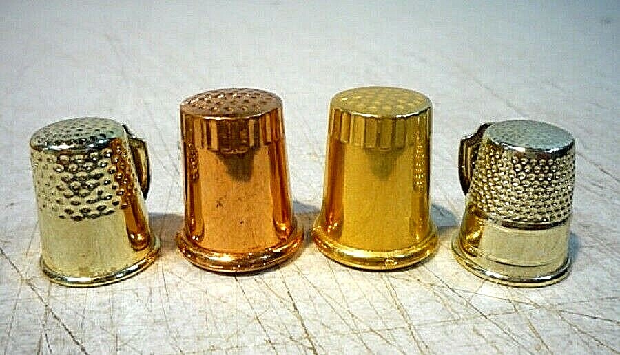 Four vintage metal plastic thimbles with designs of places and destinations.