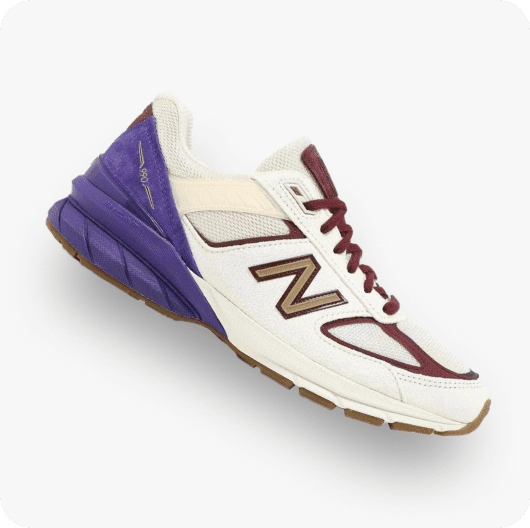 紫色和白色的运动鞋链接到New Balance 990v5“黑人历史月”购物页面