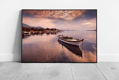 Boat Floating Calmly Over Still Water Seascape Under A Peachy Cloudy Sunset