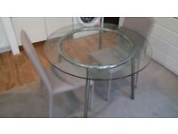 large glass-top table with two chairs can deliver