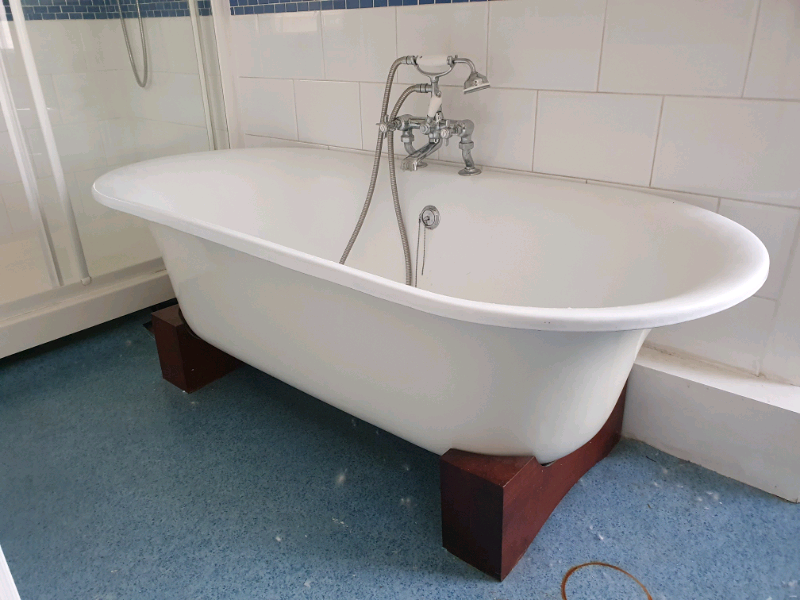 Rolltop cast iron freestanding bath with wooden feet in