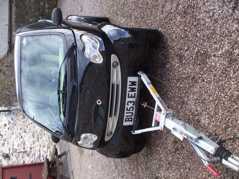 A 2003 SMART CAR WITH EURO BRAKED A FRAME FOR TOWING BEHIND A MOTORHOME
