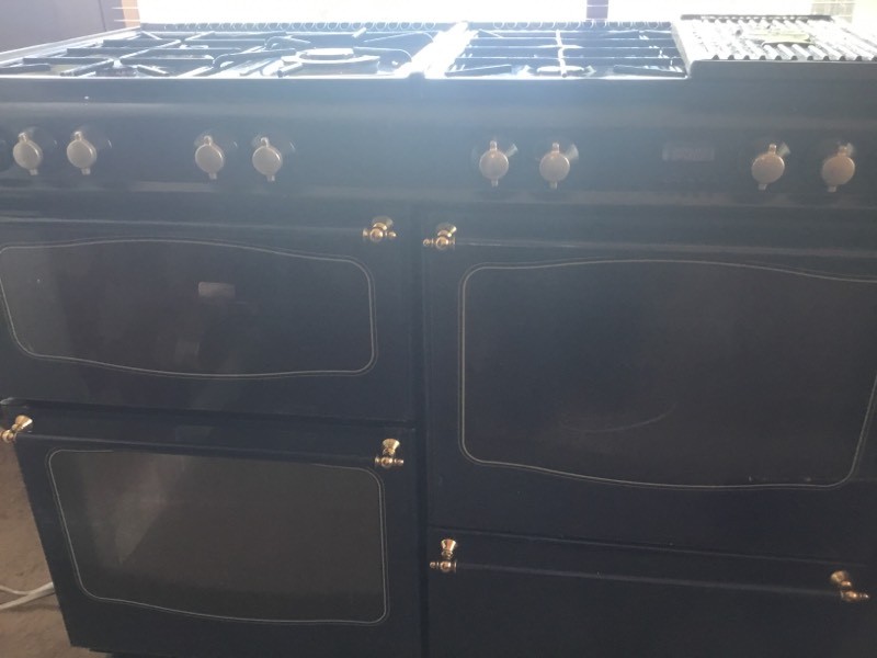 Diplomat dual fuel range cooker with matching hood and seven gas hobs