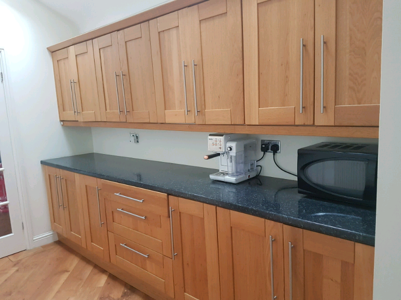 Large fitted kitchen oak cupboards & black worktophandles. . in