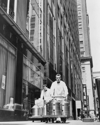 Two Schrafft's Employees wheel large coffee pots down sidewalk,1951,New York,NY