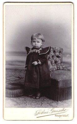 Fotografie Julius Grusche, Neugersdorf, Süßes Baby im schwarzen Kleid neben ein 