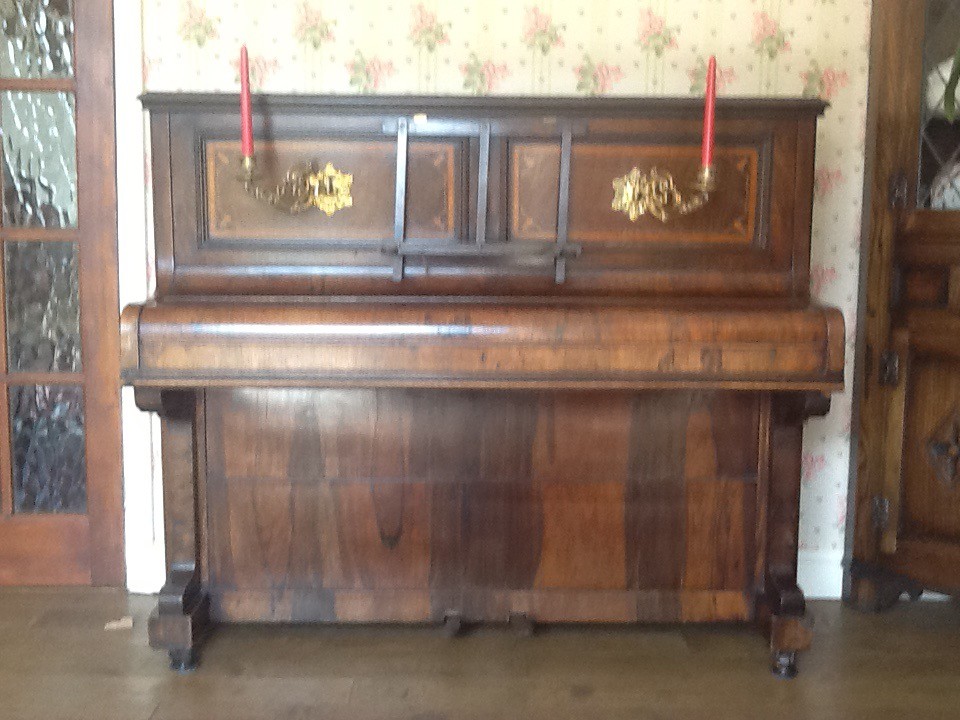 Piano,uprigh. Attractively decorated with inlay and brass candle holders in Bury St Edmunds
