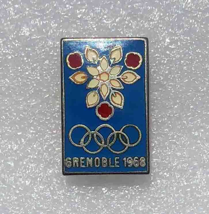 Ensemble de badges des jeux de Grenoble 1968 comprenant un badge presse sur fond jaune