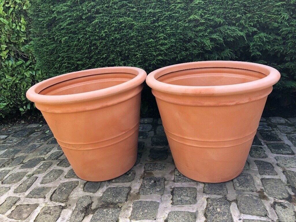 Two giant  plastic plant pots  Terracotta  in colour 