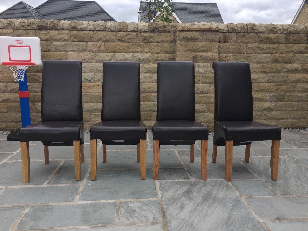 4 brown leather dining chairs with solid oak legs in Horsforth, West