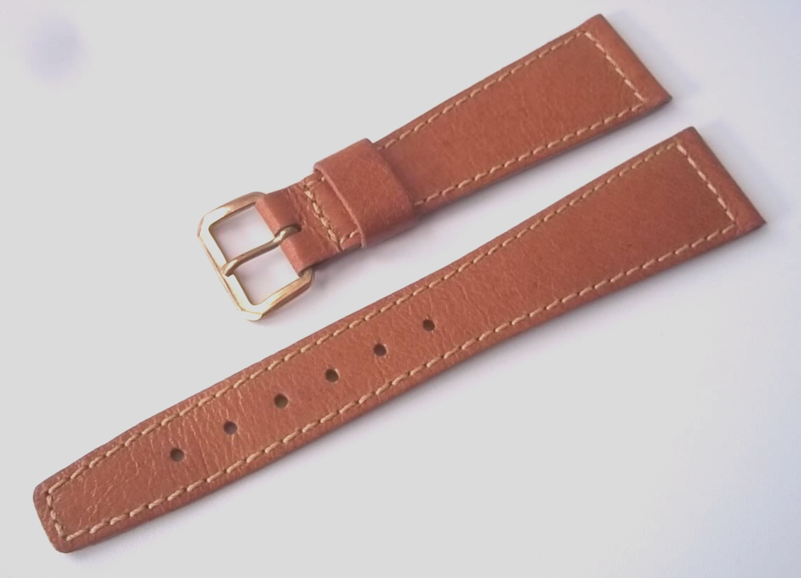Tan colored 20 mm tapered strap.Thinner type. New-old stock. Buckle has tarnish.