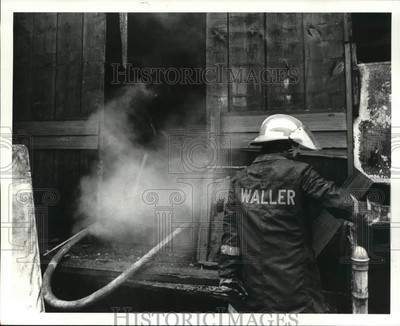 1984 Press Photo A fireman battles a blaze at house of Albert Edward Harrison