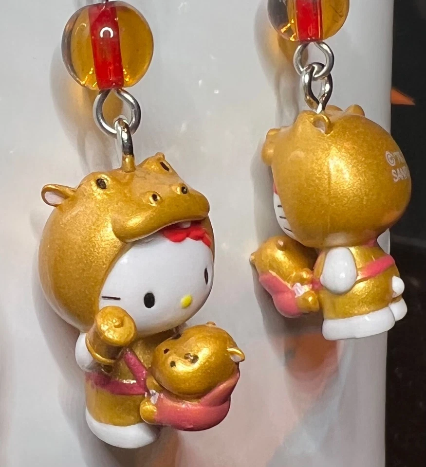 Pendientes con dije de Hello Kitty Joyería sosteniendo bebé hipopótamo. Foto 2 de 3