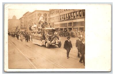 RPPC Small town MAIN STREET PARADE w Float ~ Fourth of July ? US flags Patriotic