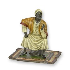 Bronze sculpture of an oriental merchant on a carpet after Franz Bergman