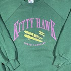 Green vintage Hanes Kitty Hawk sweatshirt with purple “Kitty Hawk North Carolina” text and yellow airplane graphic on front.