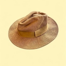 Tan straw fedora with a wide brim and a suede band. western boho
