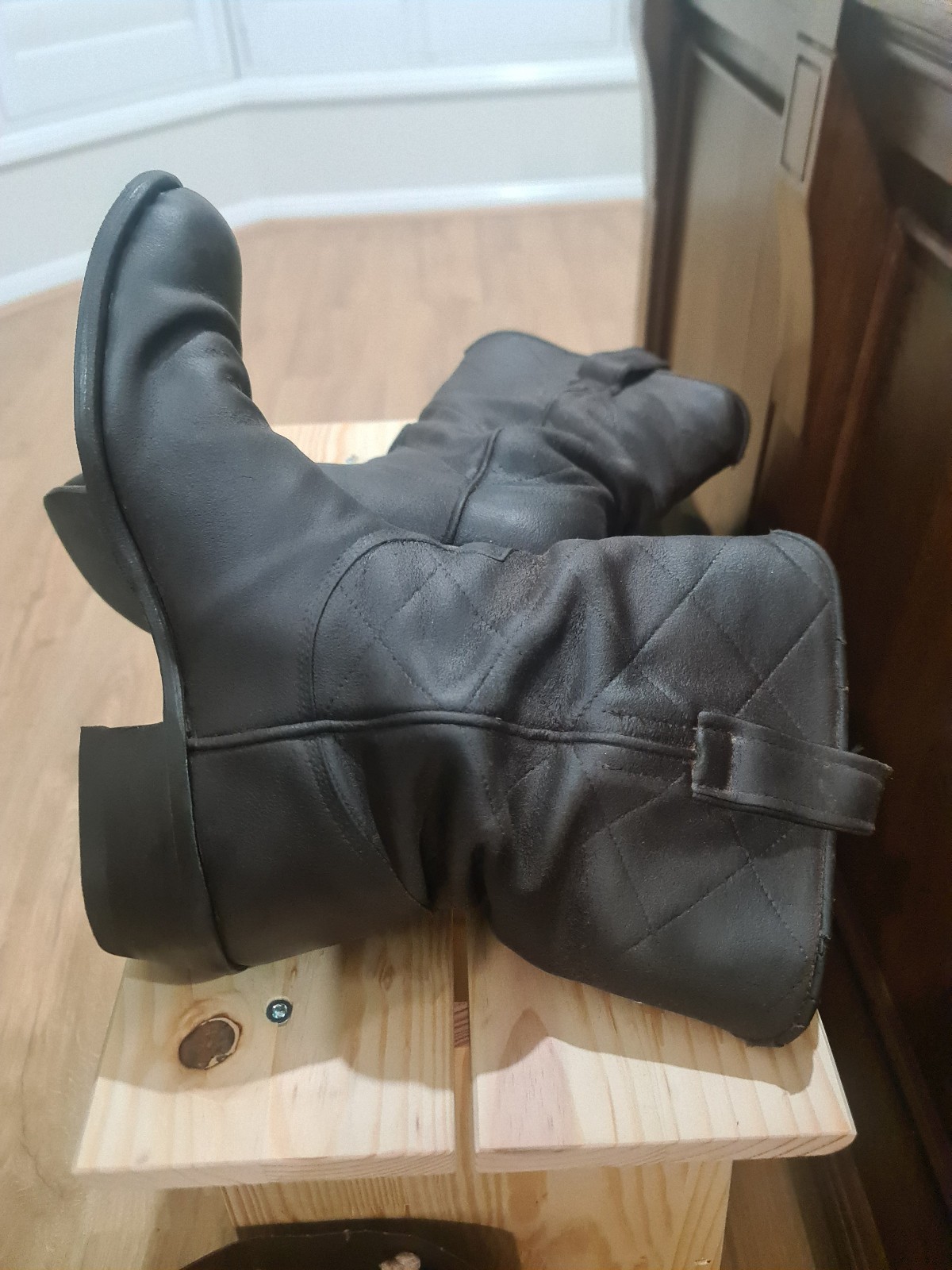 Chocolate brown oily suede pull-on riding boots with a stacked heel, shown with a small leather care kit.