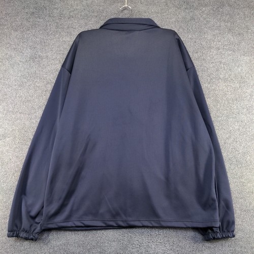 Dark blue men's full zip jacket with elastic cuffs, hanging on a gray hanger against a light gray wall.